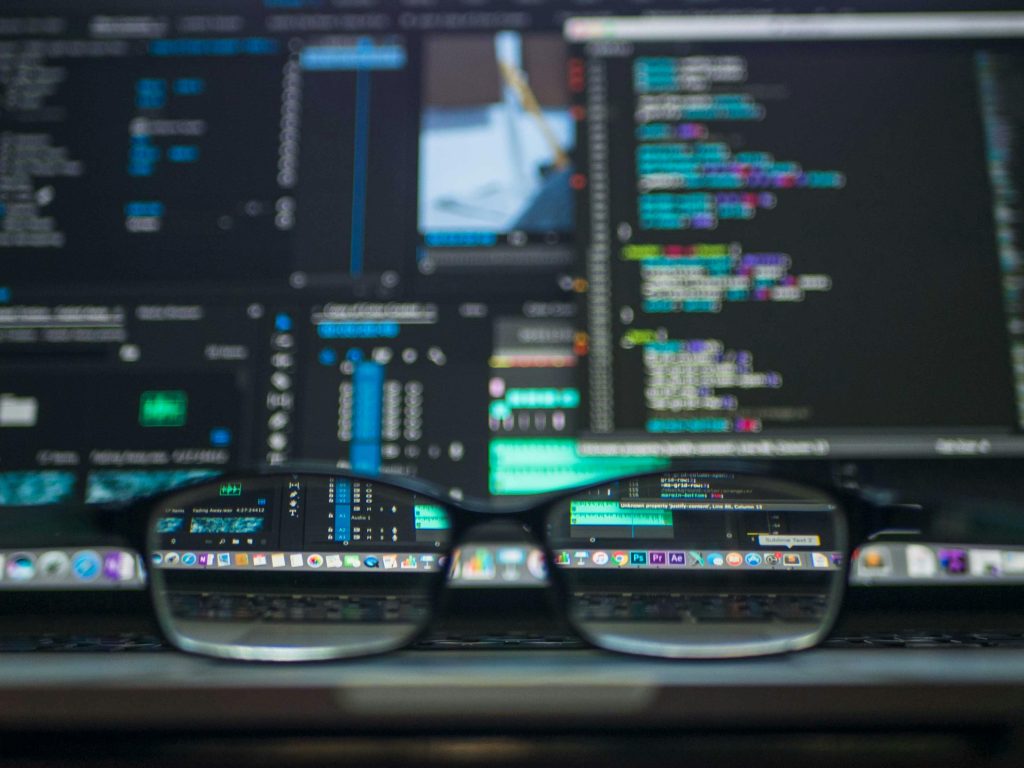 glasses sitting on top of a computer with programming on the screen